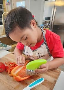Young boy with Down syndrome chopping vegetables