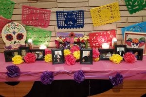 Table decorated with paper flowers, framed pictures and Mexican fiesta banners